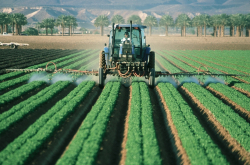 Tracteur pulvérisant une solution sur ses terres